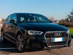 A mechanic performing maintenance on an Audi car