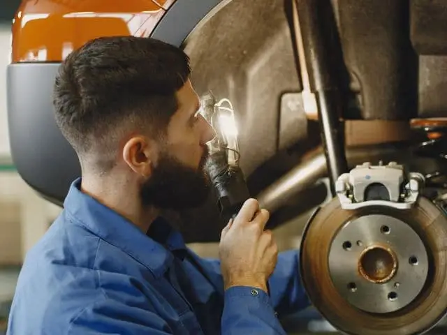 Car being serviced with a brake system flush