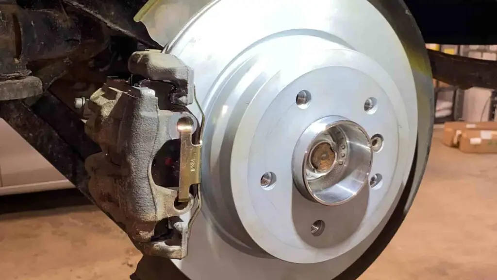 A technician at Nogueira Automotive Mechanic, LLC performing repairs and maintenance on a vehicle's brake system to ensure optimal performance and safety.