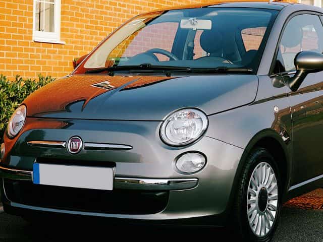 A mechanic performing a repair on a Fiat car