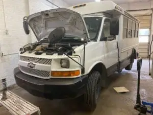 A technician at Nogueira Automotive Mechanic, LLC performing repairs and maintenance on a heavy duty vehicle, such as a truck or bus, to ensure optimal performance and reliability.