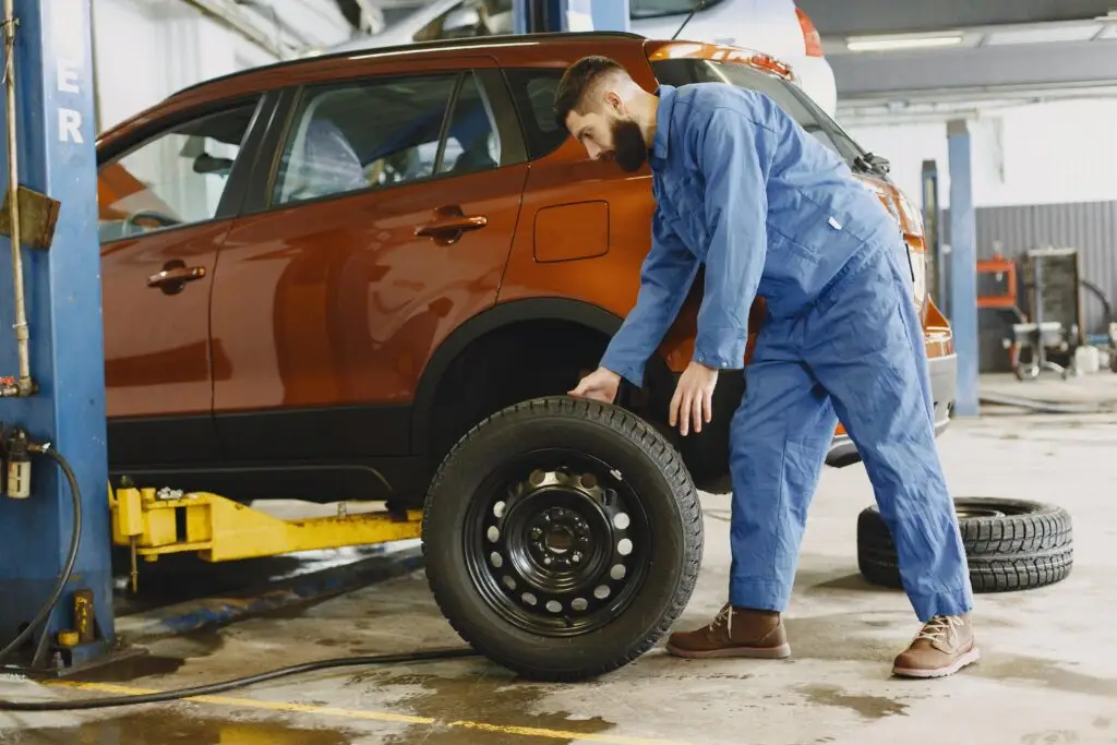 A mechanic inspecting a car tire for wear and damage