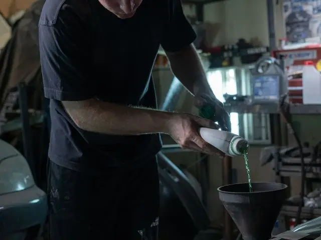 A mechanic checking a car's oil level with a dipstick