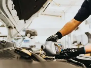 Technician performing oil change service on a vehicle at Nogueira Automotive Mechanic, LLC. Trustworthy auto repair and maintenance for your car.